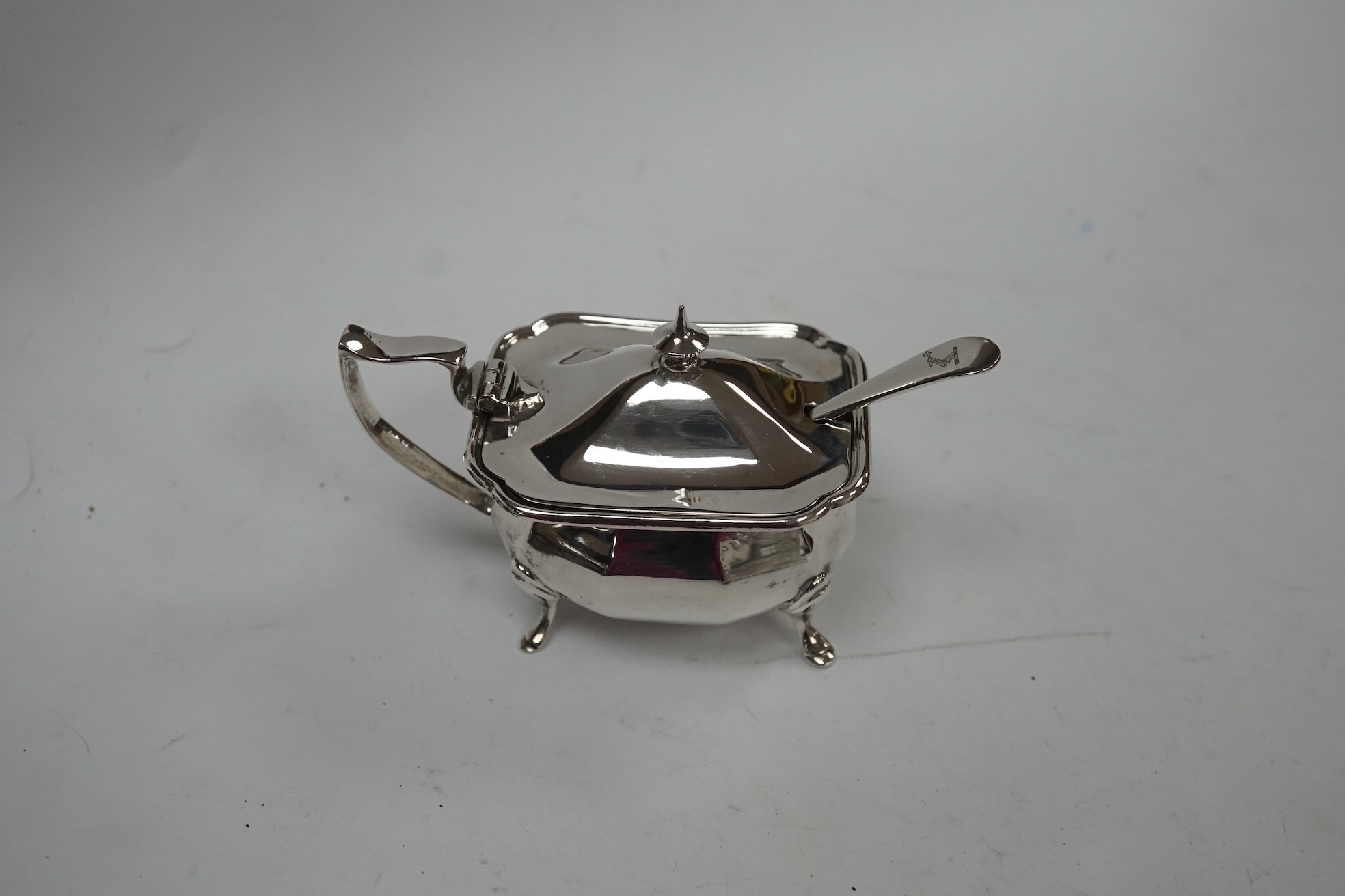 A late Victorian silver cruet stand, Jane Brownett, London, 1879, with four silver mounted bottles, different maker, Birmingham, 1879, height 67mm, together with a later silver mustard pot, a George V silver mounted phot